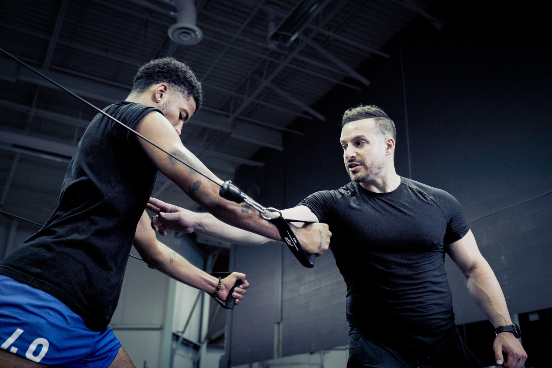 Comega coach guiding a client through cable training